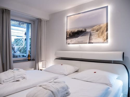 Modernes Hotelzimmer mit elegantem Doppelbett und beleuchtetem Landschaftsbild