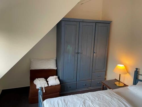 Gemütliches Schlafzimmer mit blauem Kleiderschrank und Nachttischlampe