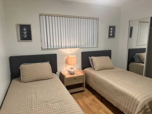 Gemütliches Schlafzimmer mit zwei Einzelbetten und Nachttisch