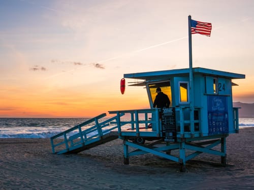 Strandwache bei Sonnenuntergang mit amerikanischer Flagge