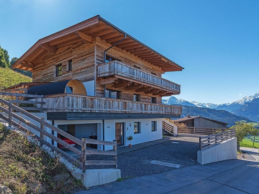 Alpenchalet mit Holzbalkon vor Bergkulisse