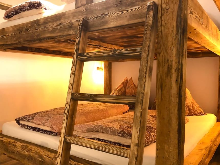 Rustikales Etagenbett aus Holz in gemütlichem Schlafzimmer.