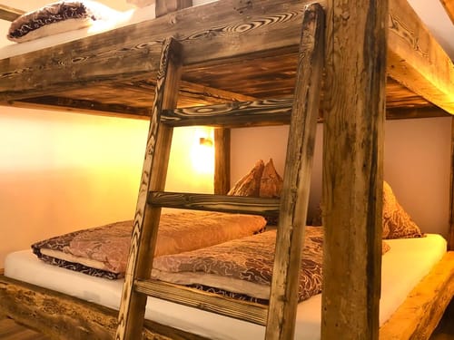 Rustikales Etagenbett aus Holz in gemütlichem Schlafzimmer.