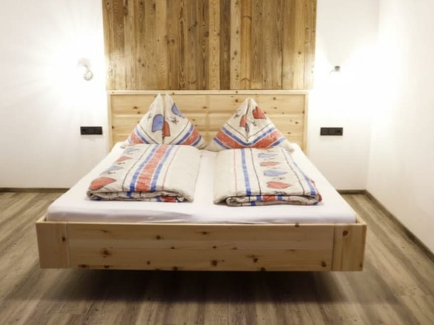Gemütliches Schlafzimmer mit einem Holzbett und bunter Bettwäsche
