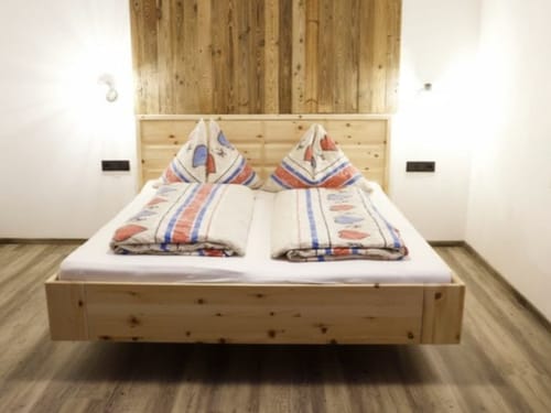 Gemütliches Schlafzimmer mit einem Holzbett und bunter Bettwäsche