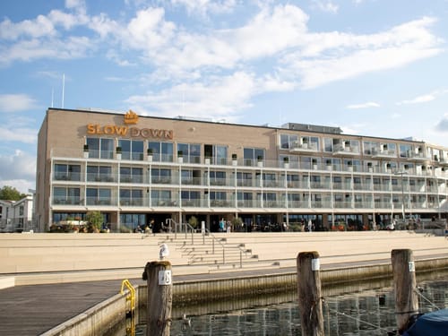 Modernes Hotelgebäude am Wasser mit dem Schriftzug "Slow Down".