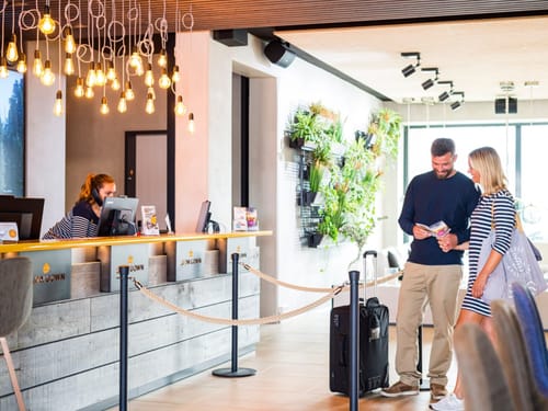 Empfangsbereich eines modernen Hotels mit Gästepaar beim Einchecken