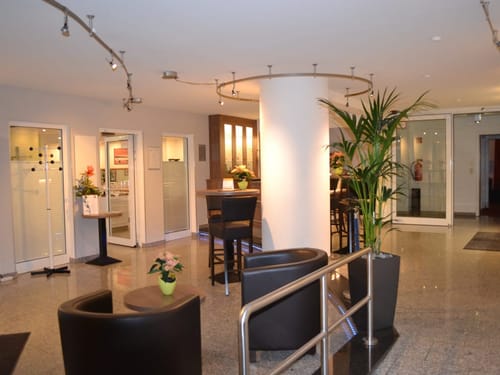 Moderner Hotel-Lobbybereich mit Sitzgelegenheiten und Begrünung