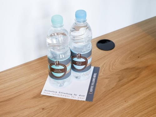 Zwei Wasserflaschen auf einem Holztisch in einem Hotelzimmer