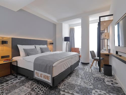 Modernes Hotelzimmer mit Doppelbett, grauer Bettwäsche und stilvollem Dekor