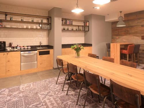 Moderne Gemeinschaftsküche mit Holztisch und Stehtheke