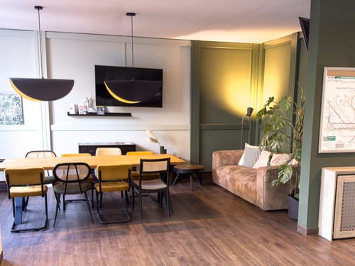 Sitzecke mit Couch, Tisch und mehreren Stühlen.