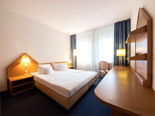 Hotelzimmer mit Doppelbett und minimalistischer Einrichtung