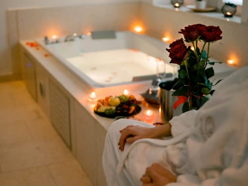Entspannende Wellness-Oase mit Badewanne, Kerzenlichtern und Rosen.
