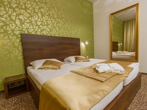 Modernes Hotelzimmer mit luxuriösem Doppelbett und stilvoller Wandgestaltung.