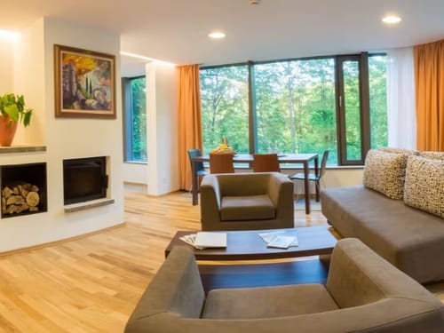 Modernes Wohnzimmer mit großem Fenster und Parkblick