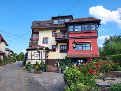 Gemütliches Landhotel mit traditioneller Fachwerkarchitektur und gepflegtem Garten in malerischer Umgebung.