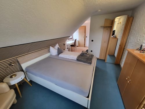 Modernes Gästezimmer im Dachgeschoss mit Doppelbett und Leseecke.