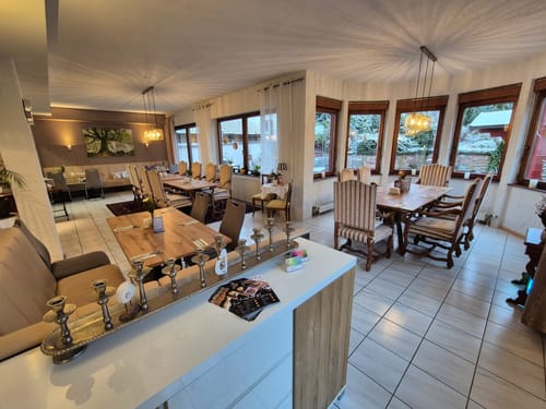 Gemütliches Restaurantinterieur mit gedeckten Holztischen und eleganter Beleuchtung