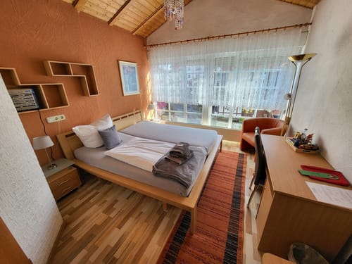 Gemütliches Schlafzimmer mit Doppelbett und Schreibtisch