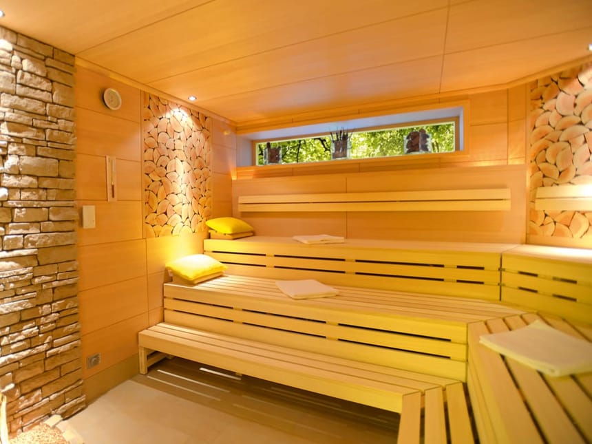 Moderne Sauna mit Holzbänken und Steinwand