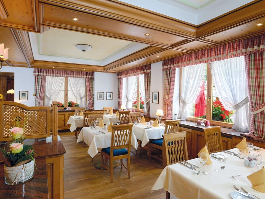 Gemütliches Restaurant mit Holzdekoration und elegant gedeckten Tischen.