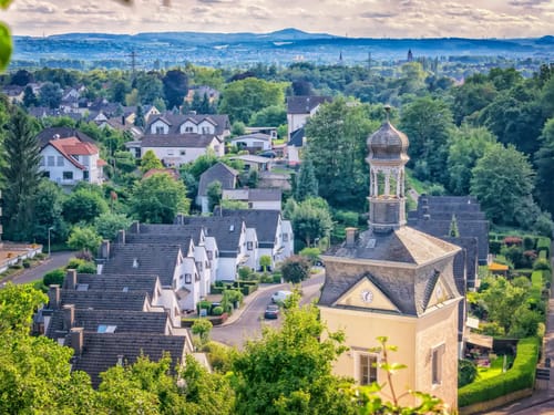 Malerische europäische Stadtlandschaft mit Kirchturm und grüner Umgebung.