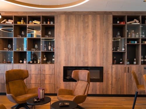 Moderne Lounge mit Holzregalen und Ledersesseln