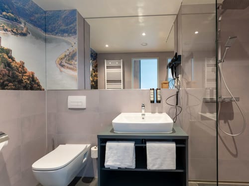 Modernes Badezimmer mit Fluss-Panorama-Tapete und Glasdusche.