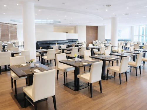 Modernes Restaurantinterieur mit weißen Stühlen und Holztischen