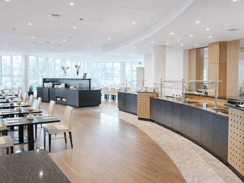 Entdecken Sie ein stilvolles Restaurantinterieur mit modernen Möbeln und heller Beleuchtung. Ideal für ein gehobenes Dining-Erlebnis in entspannter Atmosphäre.