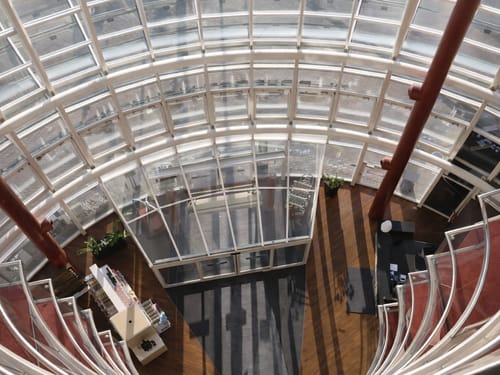 Blick auf die moderne, kreisförmige Glasarchitektur eines Gebäudes von oben.