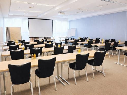 Moderner Konferenzraum mit Reihenbestuhlung und Präsentationstechnik