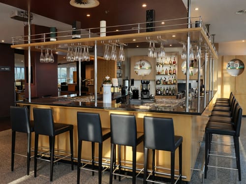 Moderne, stilvolle Bar mit eleganter Theke und Barhockern aus Leder.