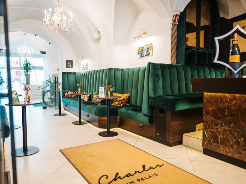 Elegantes Café-Interieur mit grünen Samt-Sitzbänken und Kronleuchtern