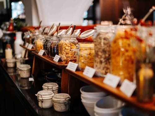 Frühstücksbuffet mit verschiedenen Cerealien in Glasbehältern