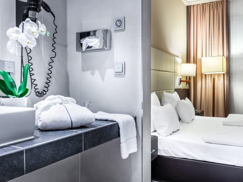 Modernes Hotelzimmer mit elegantem Badezimmer und komfortablem Bett.