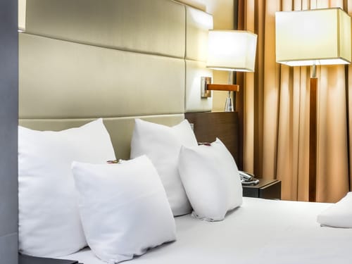 Modernes Hotelzimmer mit luxuriösem Bett und eleganter Beleuchtung