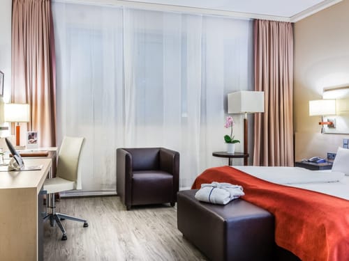 Modernes Hotelzimmer mit Schreibtisch und komfortablem Bett