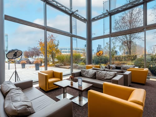 Modernes Foyer mit gelben Sesseln und großen Fenstern