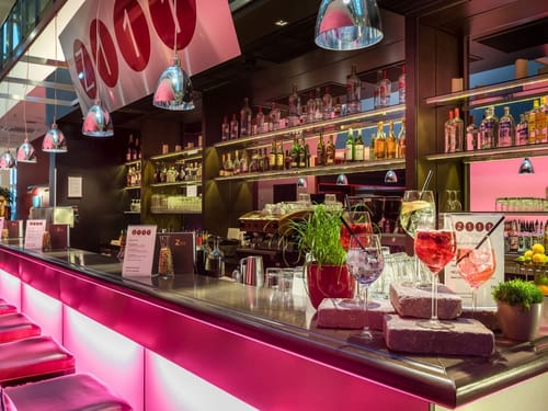 Moderne Cocktailbar mit stilvoller Beleuchtung und bunter Drink-Auswahl