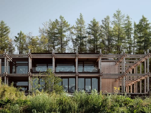 Moderner Holzbau mit großen Glasfronten und natürlicher Umgebung