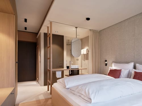 Modernes Hotelzimmer mit Doppelbett und offenem Badezimmerdesign