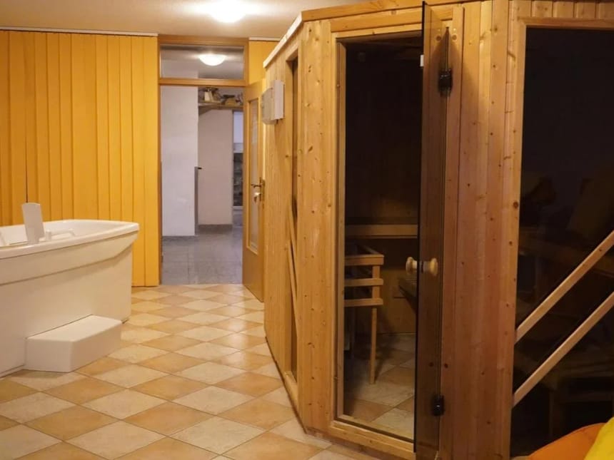 Sauna mit Holztüren und Whirlpool im Entspannungsbereich.