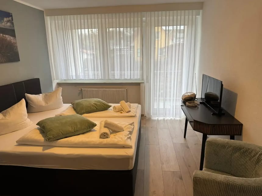 Modernes Hotelzimmer mit Doppelbett, Flachbildfernseher und stilvoller Einrichtung.