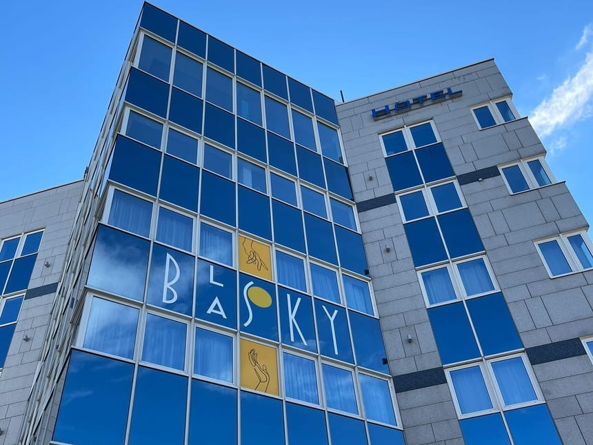 Modernes Hotelgebäude mit Glasfassade unter blauem Himmel