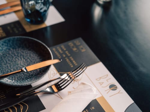 Elegantes Tischgedeck mit Teller, Besteck und Serviette in einem Restaurant.