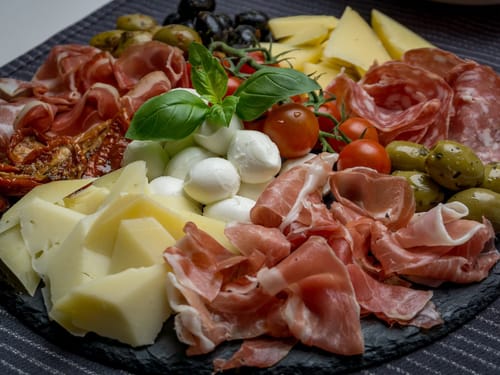Italienische Antipasti-Platte mit Schinken, Käse, Tomaten und Oliven.