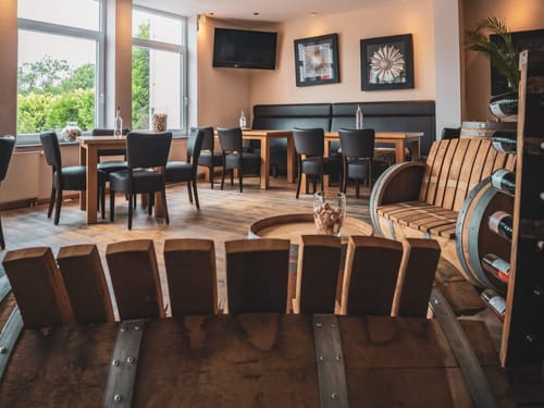 Gemütliche Lounge mit Holzmöbeln und Weinfässern