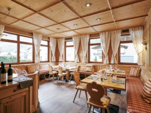 Gemütliches, traditionelles Restaurant mit Holzdekoration und großen Fenstern